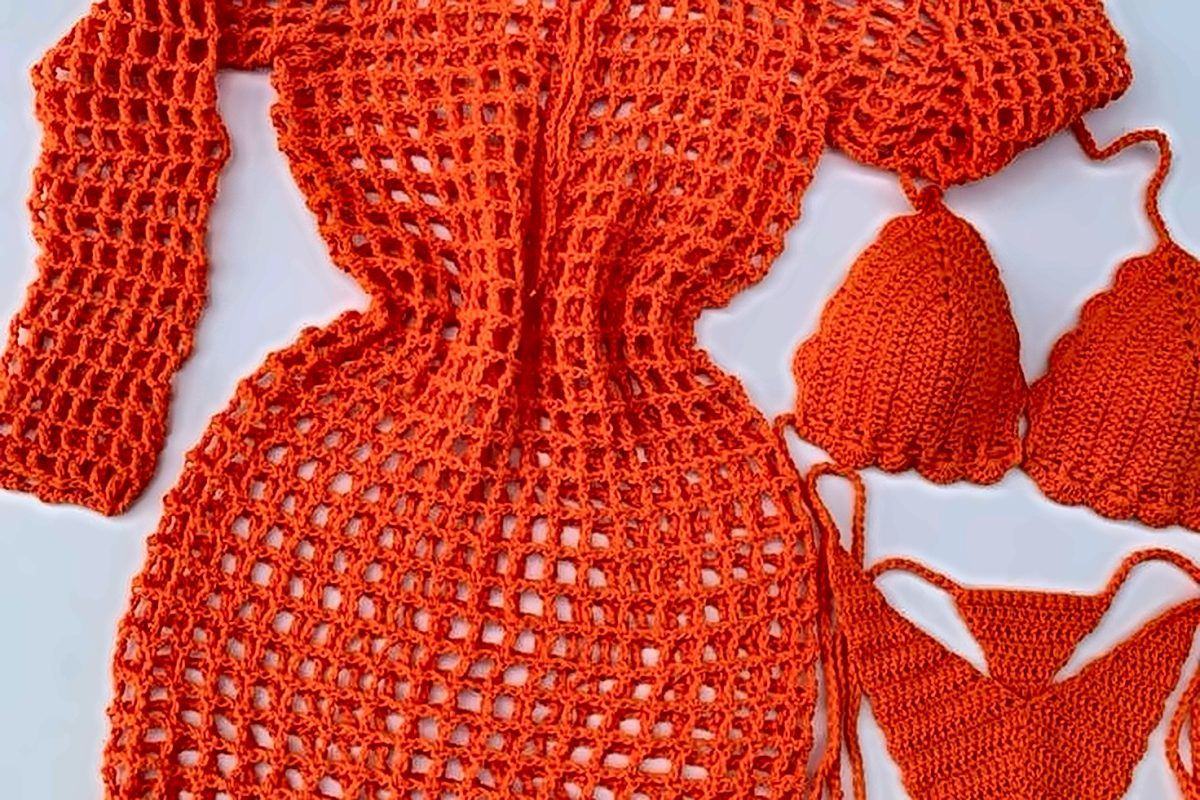 An orange crochet dress, hat, and bikini laid out flat